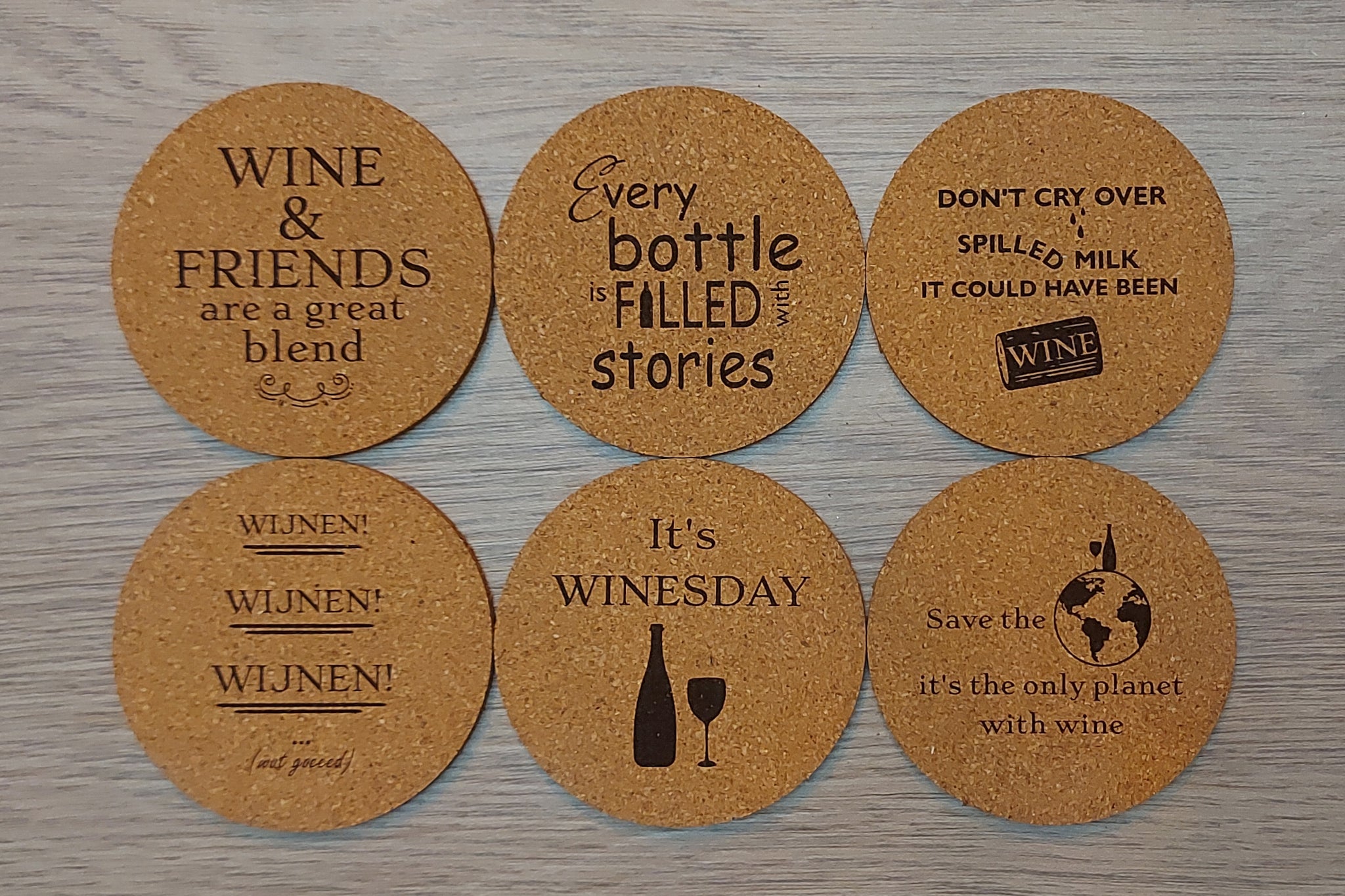 Kurken onderleggers met leuke quotes. Gravure van onderzetters met quotes 'Wine & Friends are a great blend', 'Every bottle is filles with stories', 'Don't cry over spilled milk, it could have been wine', 'Wijnen, wijnen, wijnen', 'It's Winesday', 'Save the planet, it's the only planet with wine'
