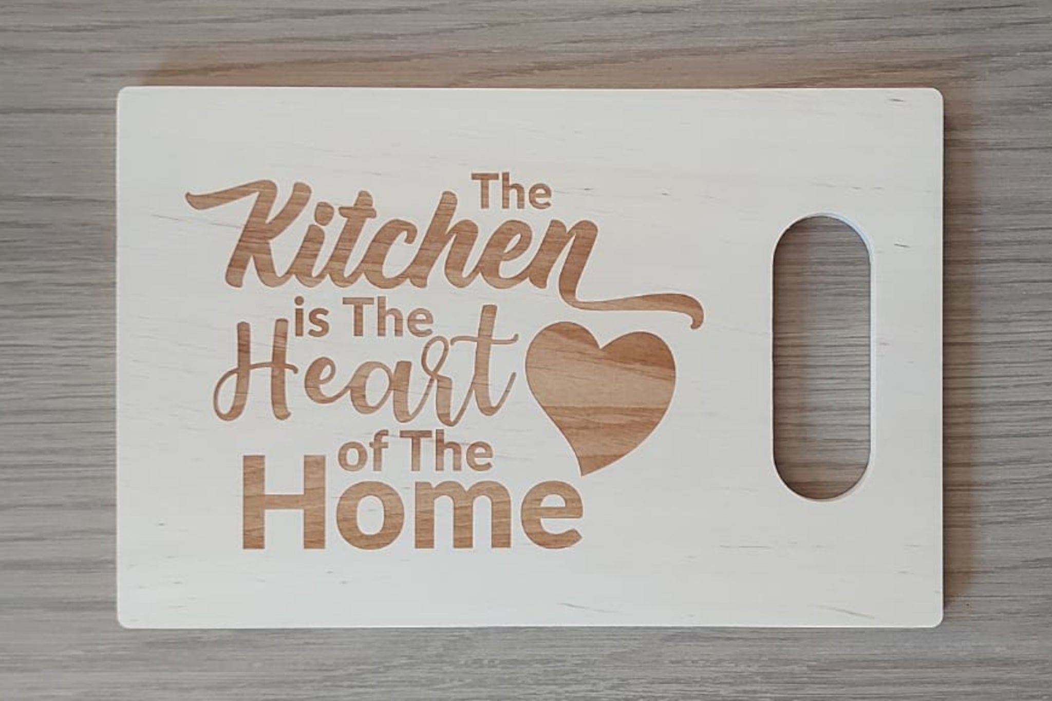 Houten tapasplank, snijplank, serveerplank rechthoek met handvat. Afgewerkt met mooie gravure van 'The kitchen is the heart of the home'. 