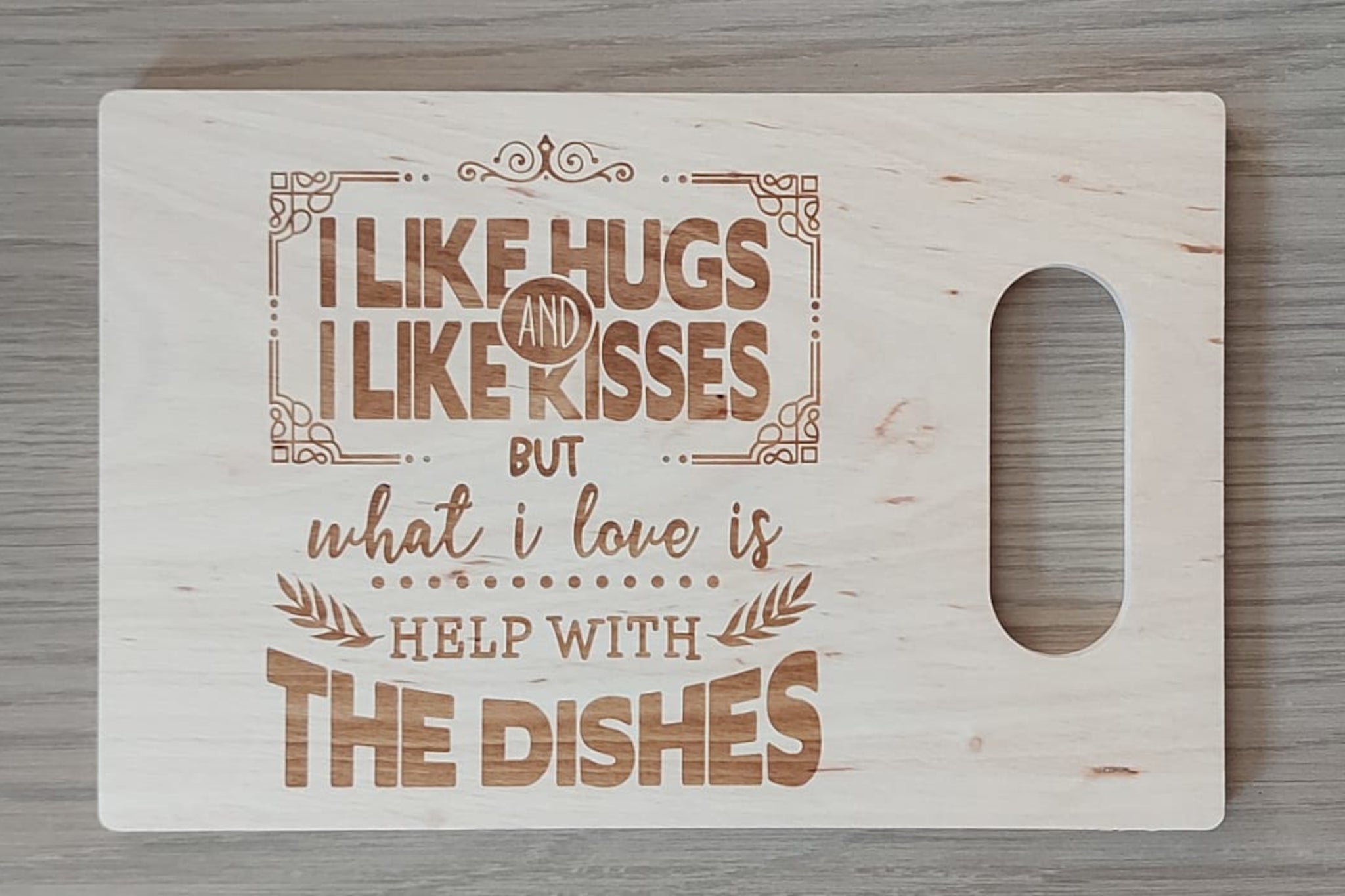 Houten tapasplank, snijplank, serveerplank rechthoek met handvat. Afgewerkt met mooie gravure van 'I like hugs and I like kisses but what I love is help with the dishes'. 