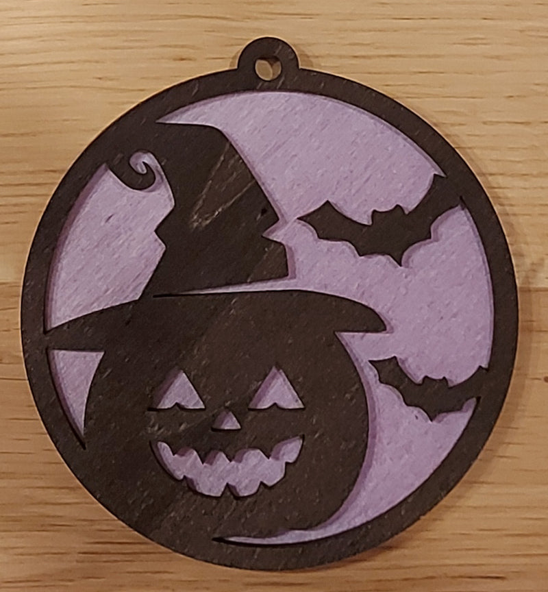 Houten en gekleurde Halloween decoratie. Halloween hanger met gravure griezelige pompoen en vleermuizen