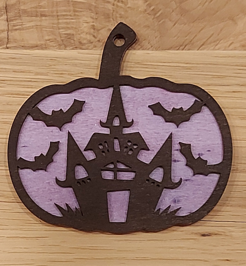 Houten en gekleurde Halloween decoratie. Halloween hanger met gravure van een kasteel en vleermuizen