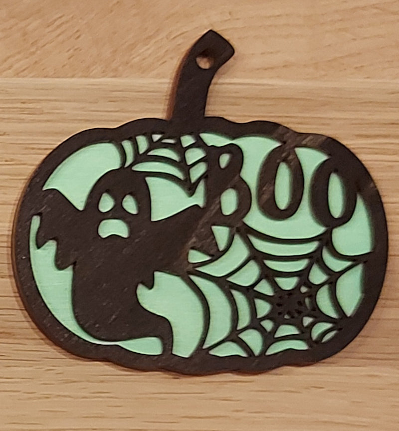 Houten en gekleurde Halloween decoratie. Halloween hanger met gravure van een spookje en spinnenwebben