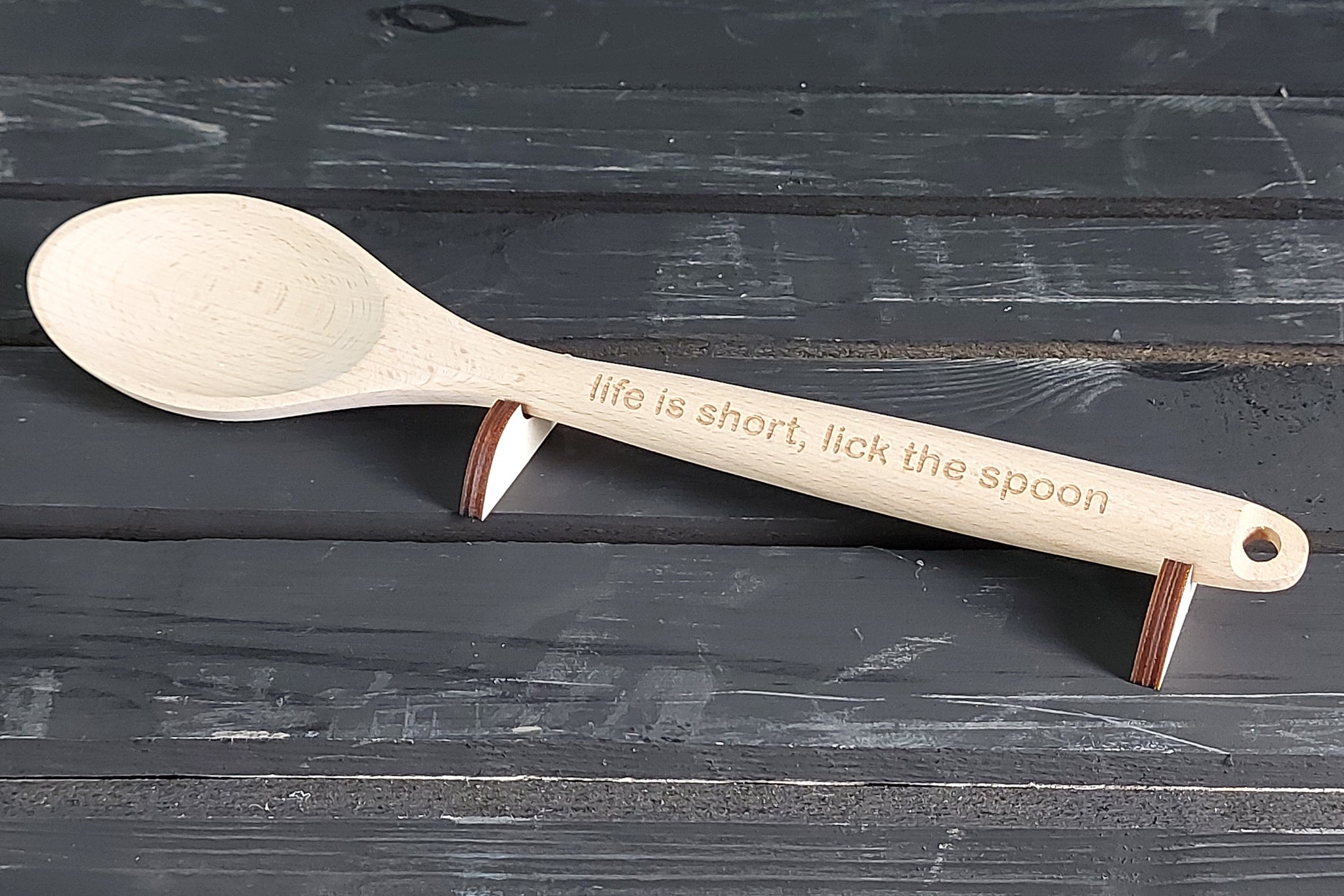 Houten lepel met gepersonaliseerde tekst voor cadeau. 'Life is short, lick the spoon' spreuk gegraveerd.