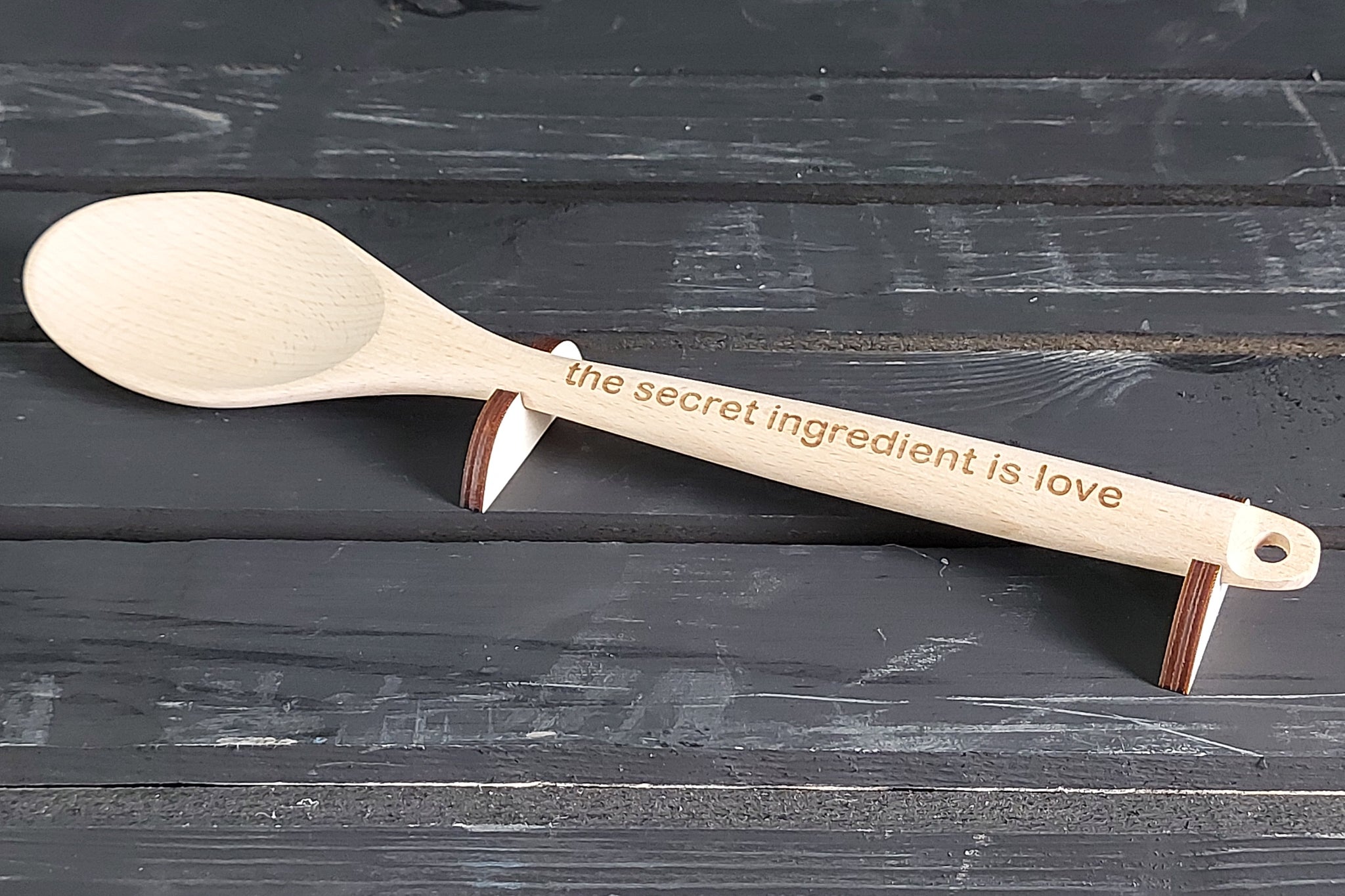 Houten lepel met gepersonaliseerde tekst voor cadeau. 'The secret ingredient is love' spreuk gegraveerd.