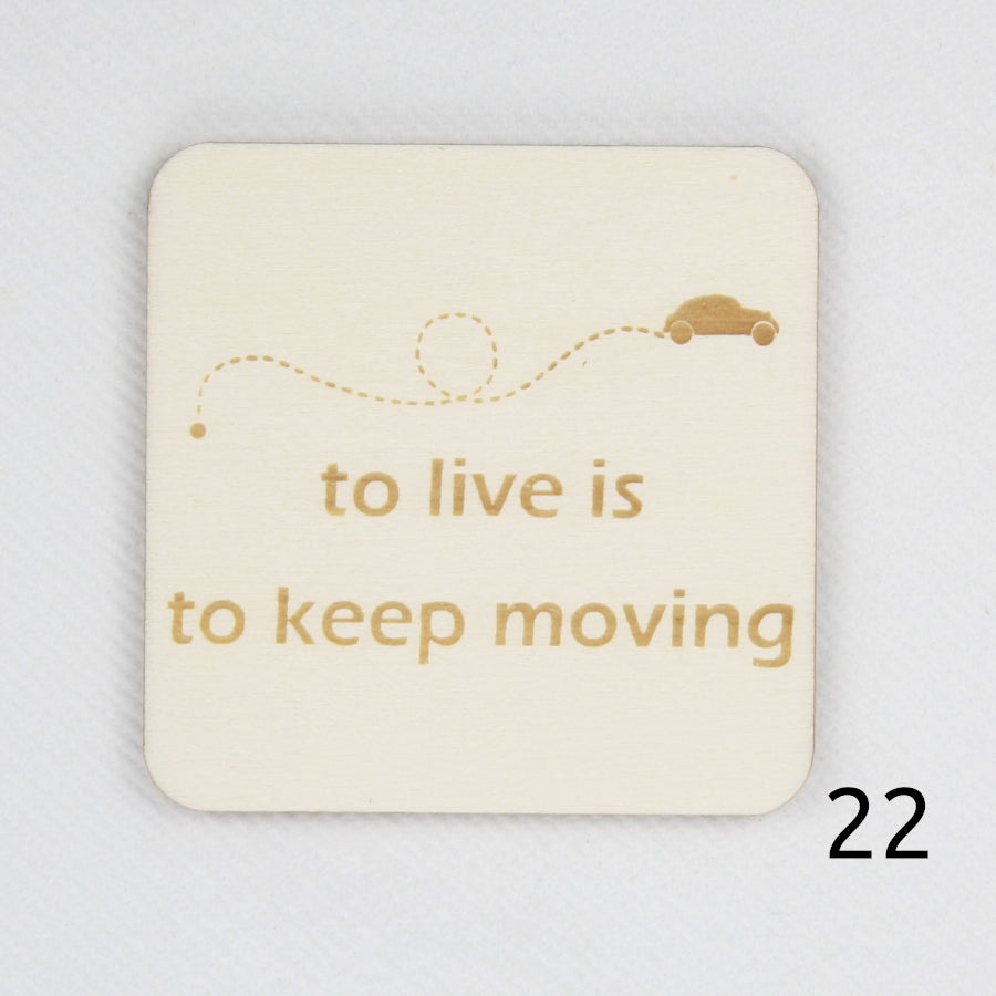 Houten magneet. Gegraveerde magneet. Gravure met spreuk 'To live is to keep moving'.