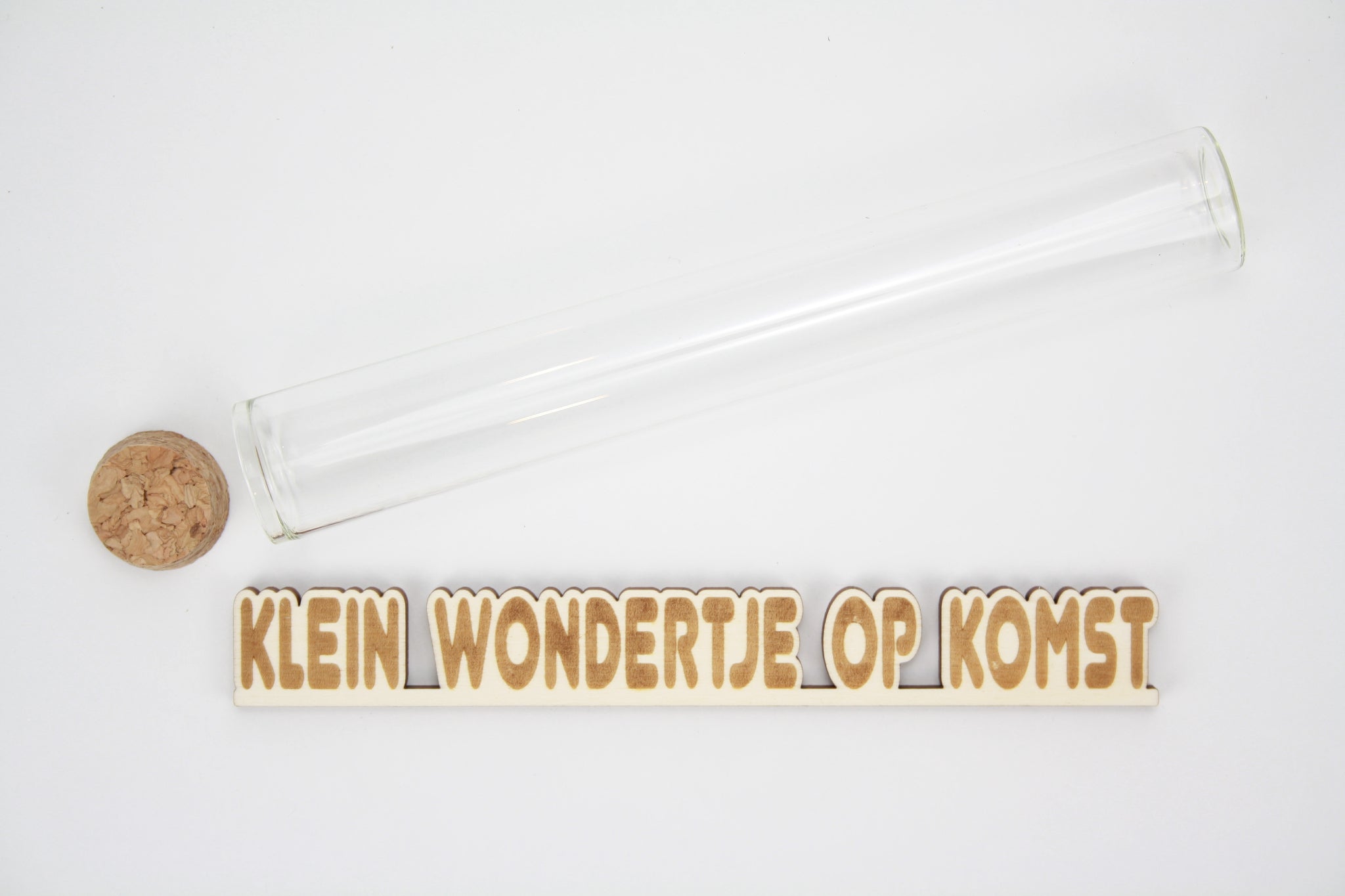 Message in a tube, aankondiging in proefbuis. lasercut gravure van 'Klein wondertje op komst'.