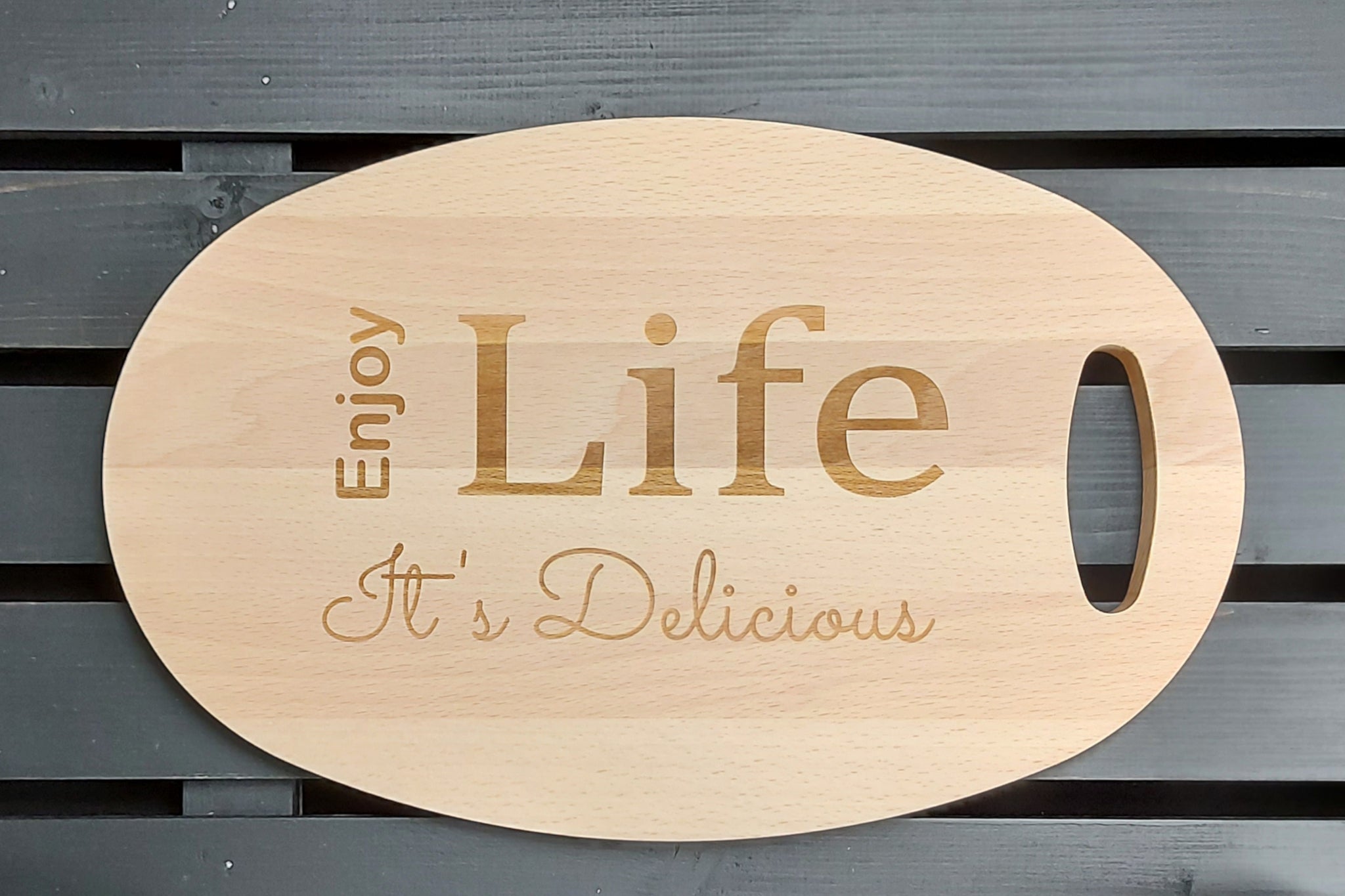 Beuken houten ovalen tapasplank, snijplank, serveerplank. Snijplank handgemaak. Afgewerkt met gravure van 'Enjoy life it's delicious'.